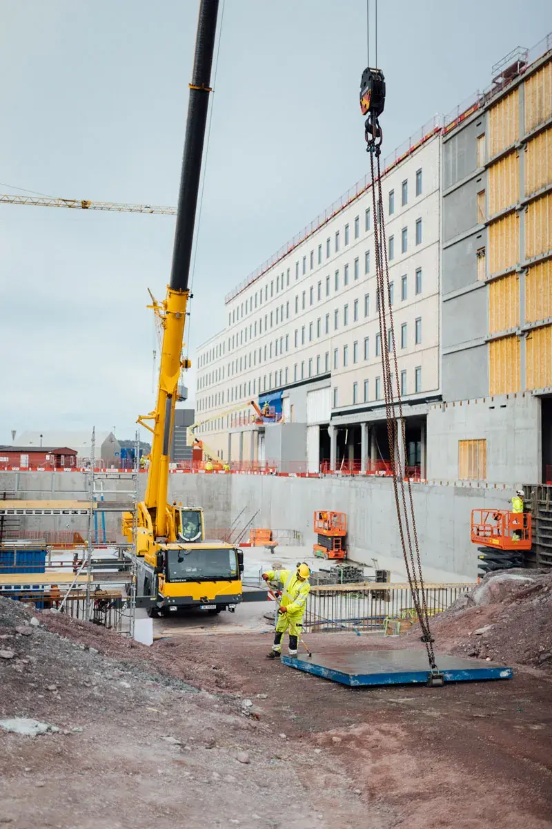 Byggeplass med kran og arbeider i refleksvest